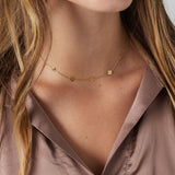 Model trägt Daisiana Necklace Gold mit filigranen Glückssymbolen aus vergoldetem Edelstahl