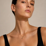 Model trägt Xena Necklace Gold mit Mond Anhänger, Perle und Strassstein