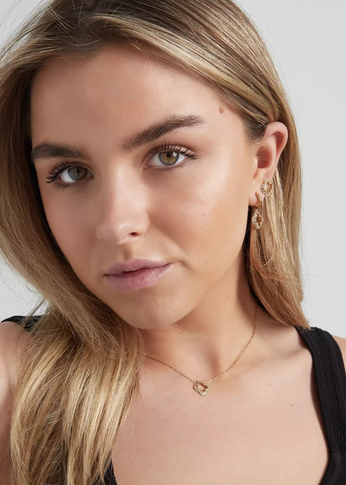 Elegantes goldenes Schmuckset für Damen mit Halskette und Ohrringen, getragen von Model, zeitloses Design mit funkelnden Details