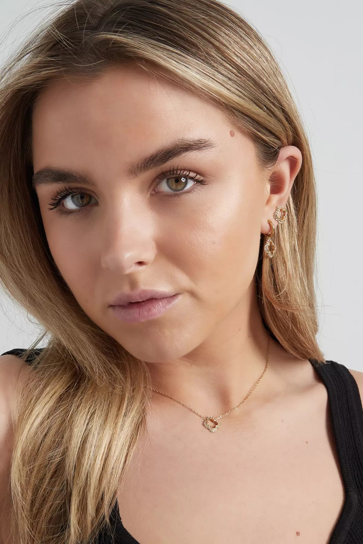 Elegantes goldenes Schmuckset für Damen mit Halskette und Ohrringen, getragen von Model, zeitloses Design mit funkelnden Details