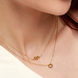 Frau trägt goldene Knoten Halskette aus vergoldetem Edelstahl von OLANA W. im minimalistischen Layering Look.
