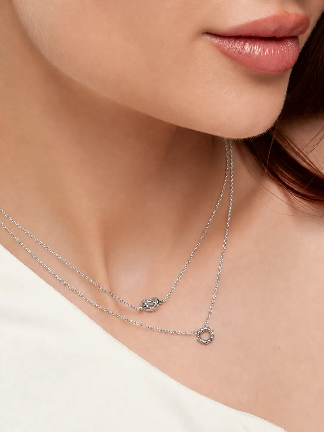 Frau trägt silberne Knoten Halskette aus Edelstahl von OLANA W. im minimalistischen Layering Look.