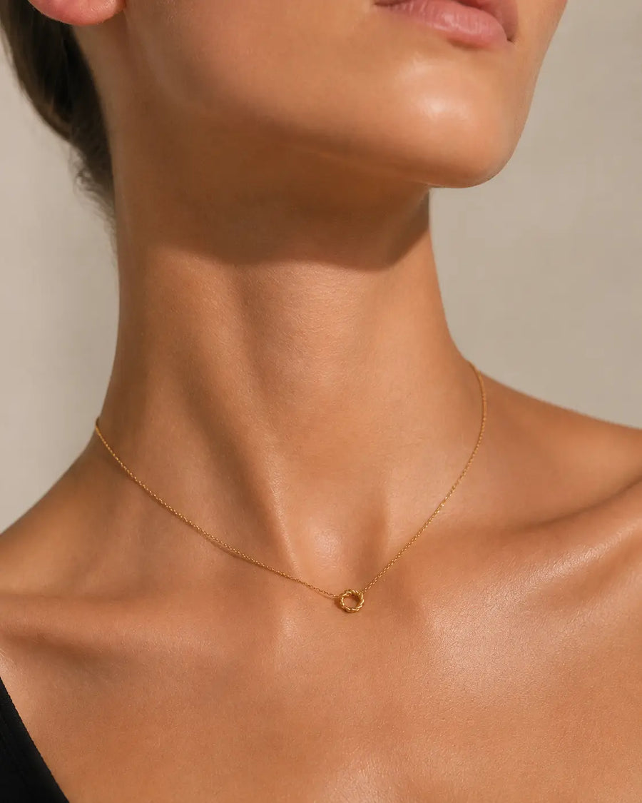 Frau trägt goldene Kreis Halskette aus vergoldetem Edelstahl von OLANA W. im minimalistischen Look.