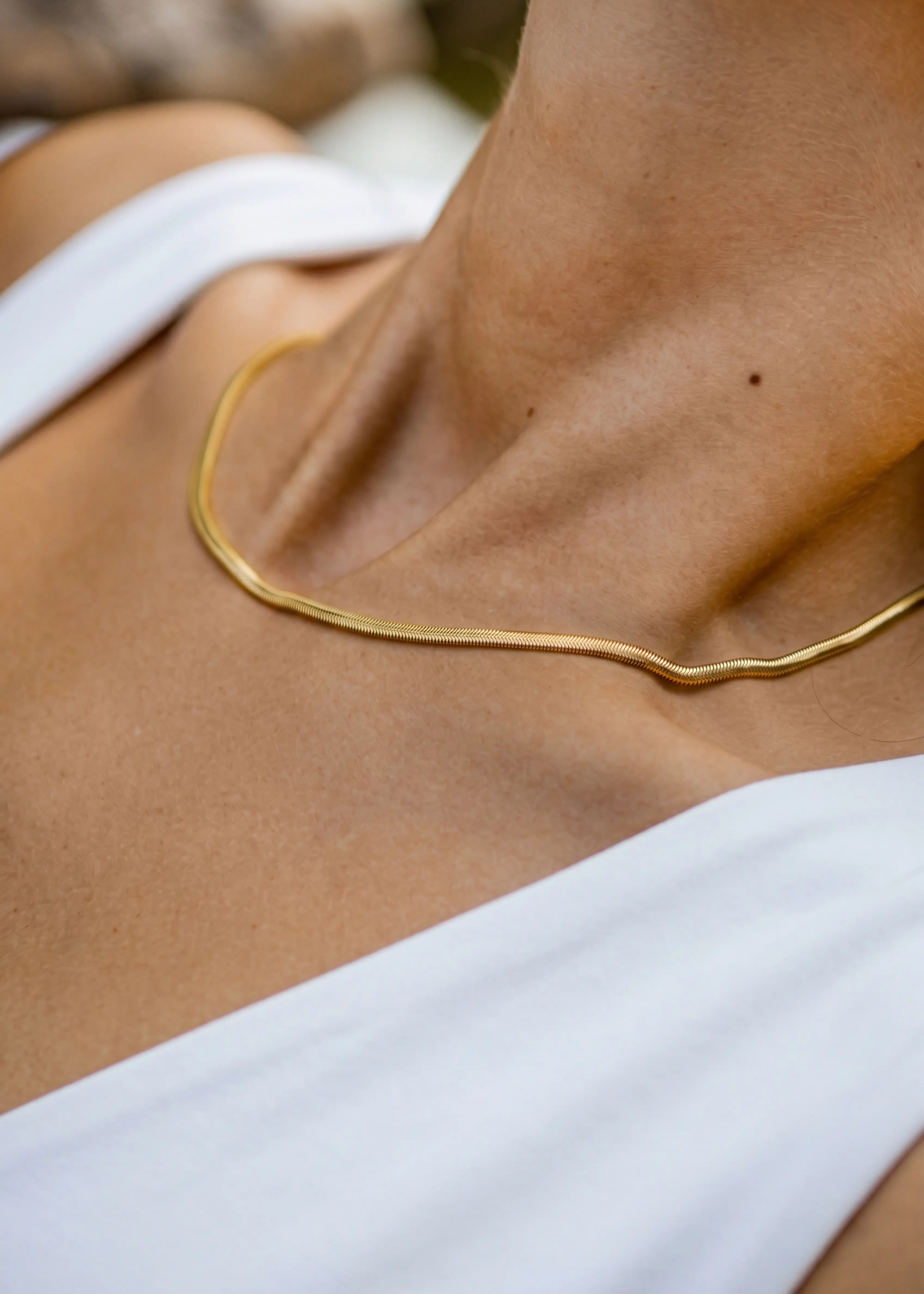 Frau trägt goldene Snake Chain Halskette aus vergoldetem Edelstahl von OLANA W. im minimalistischen Look.