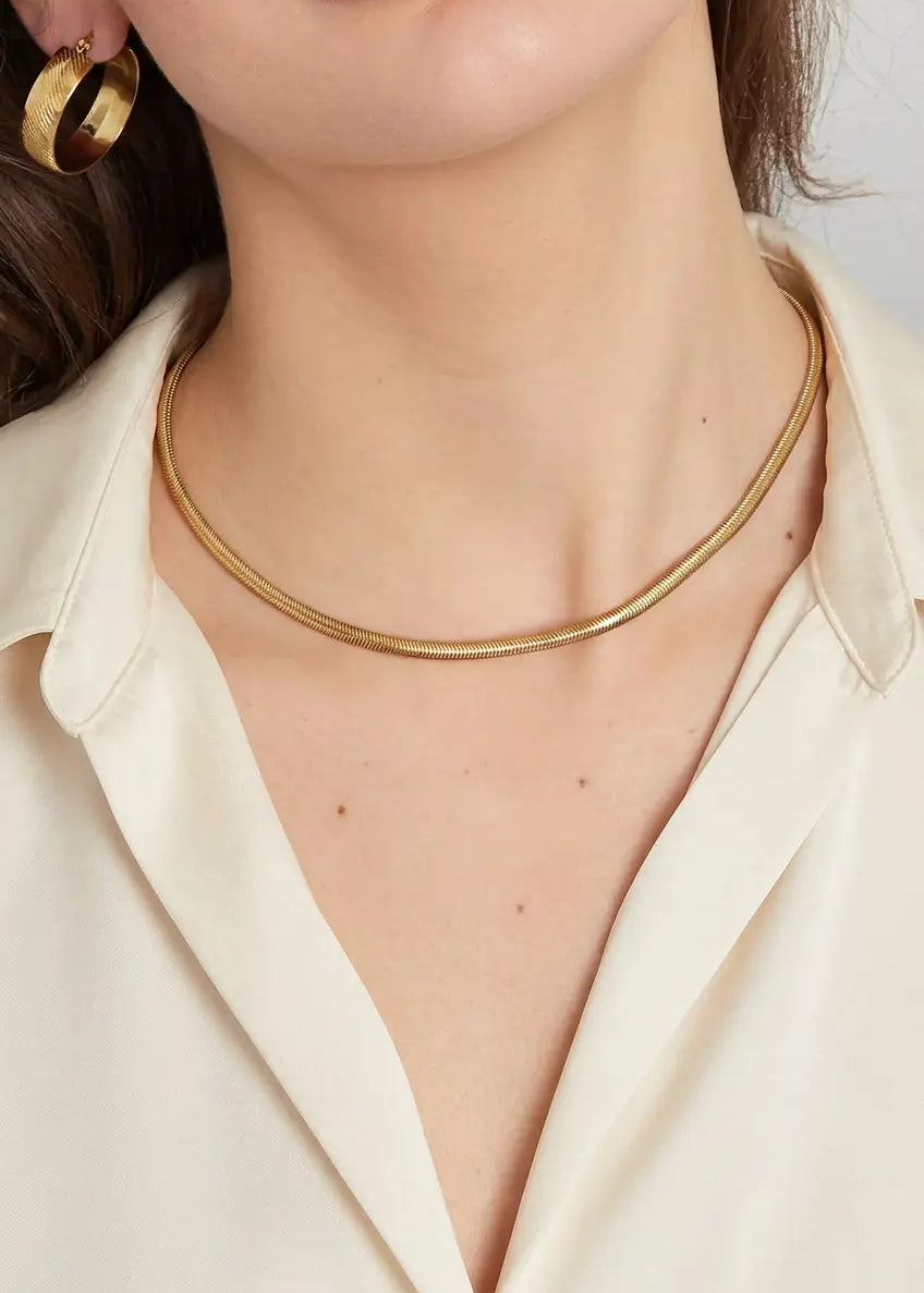Frau trägt goldene Snake Chain Halskette aus vergoldetem Edelstahl von OLANA W. im minimalistischen Look. 1