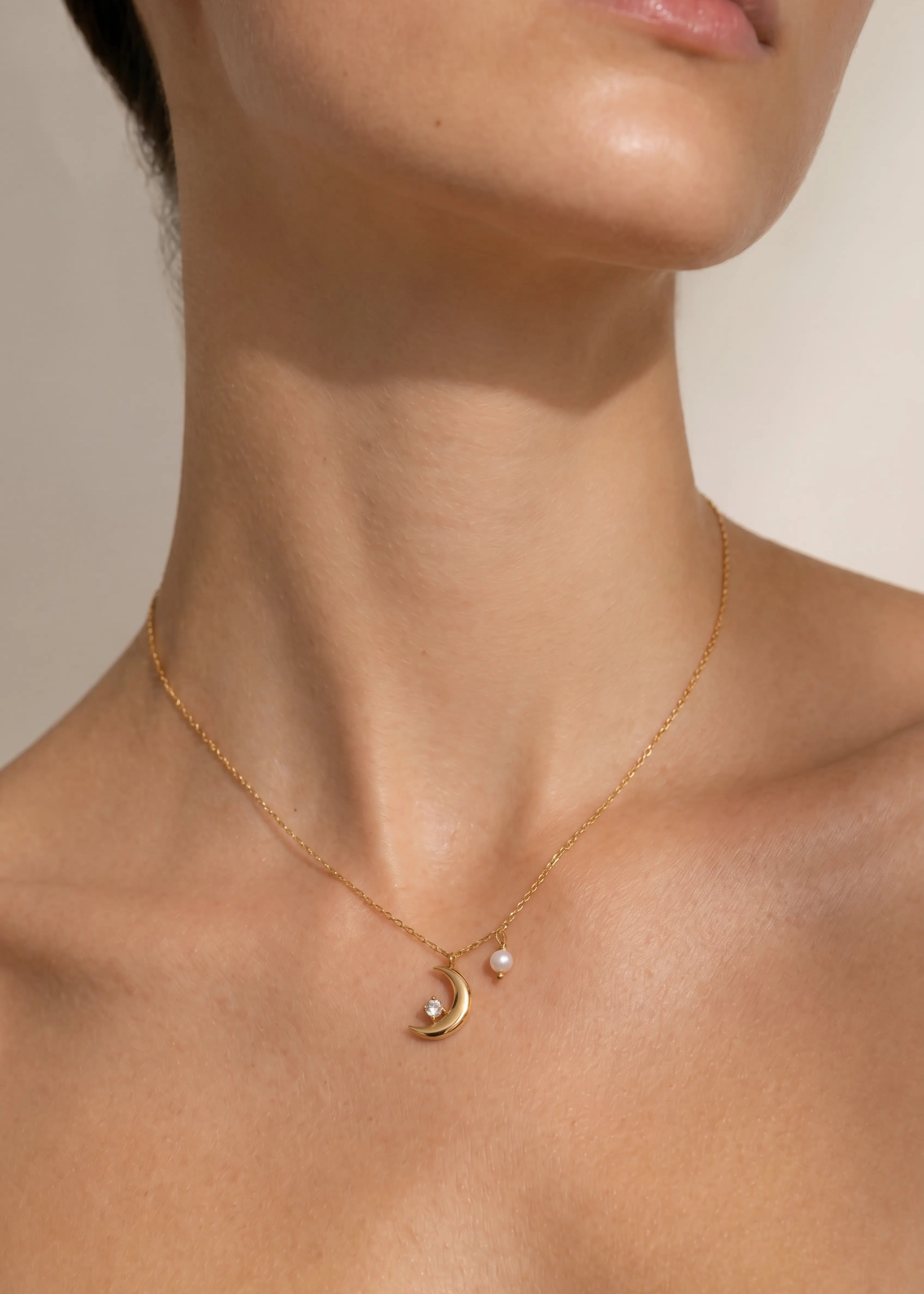 Model trägt Xena Necklace Gold mit Mond Anhänger, Perle und Strassstein